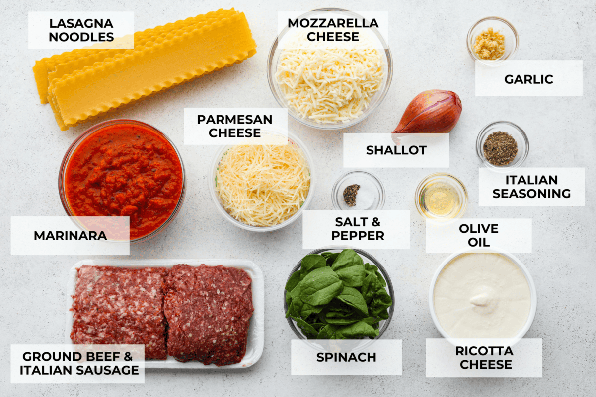 A top view of all of the ingredients for sheet pan lasagna in individual bowls, each labeled. 