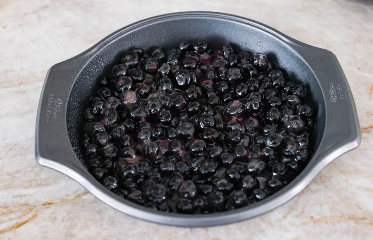 Fourth photo of the blueberry and sauce mixture in the bottom of the pan.