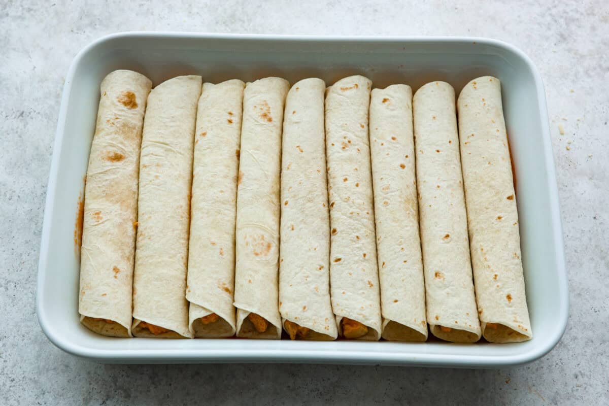 Sixth photo of the enchiladas layered in the baking dish.