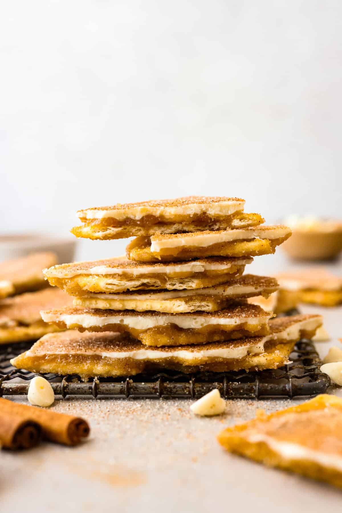 Churro crack broken and stacked in a pile on a cooling rack. 