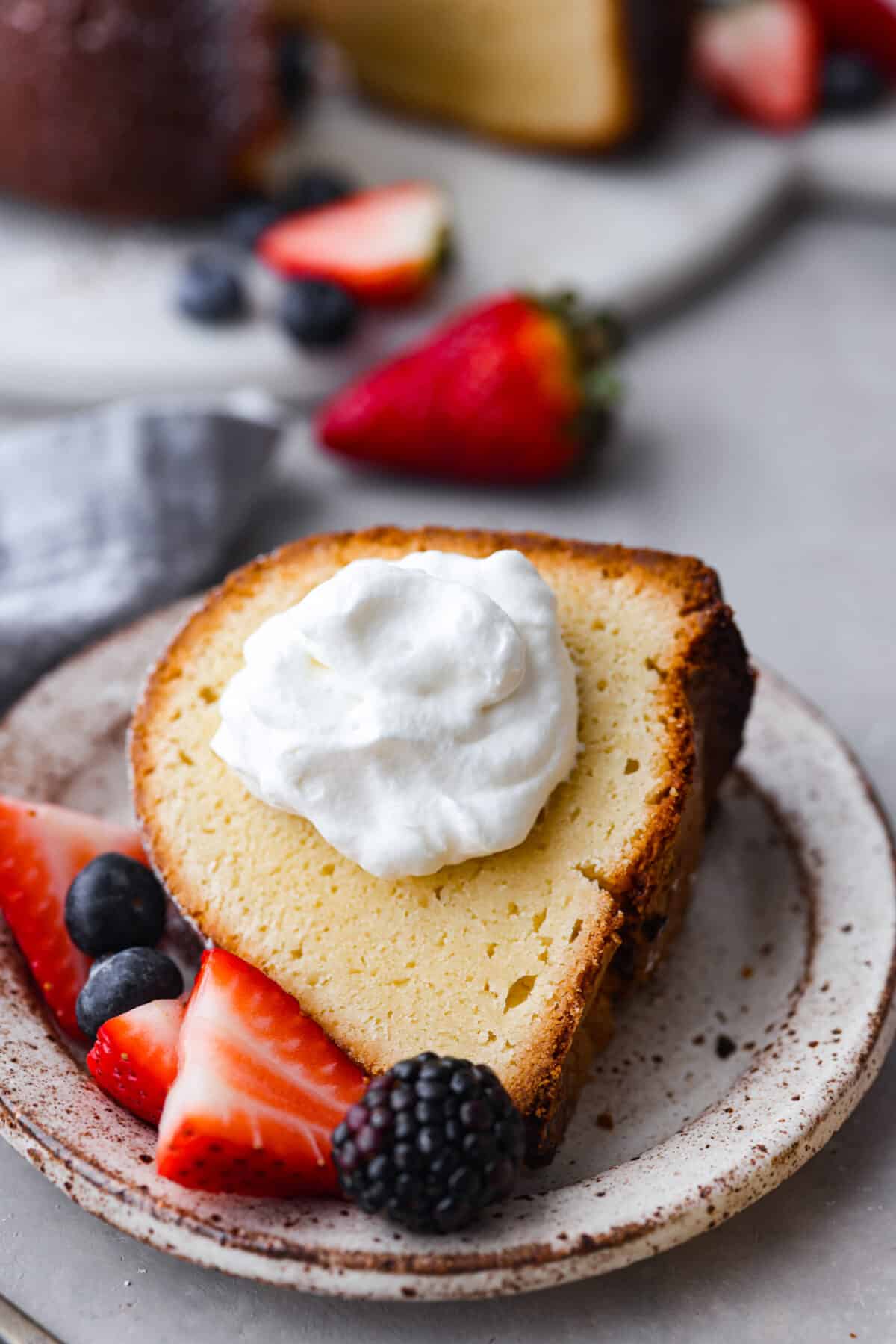 A slice of cake with a dollop of whipped cream on it.