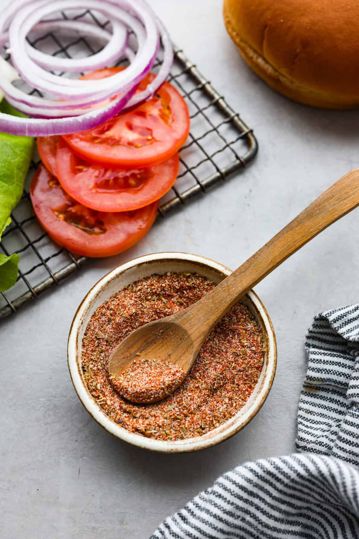 Burger seasoning in a small bowl with a wood spoon. 