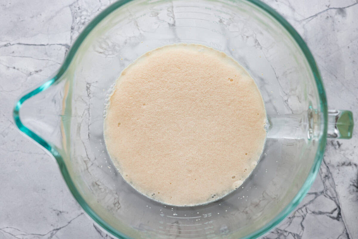 First photo of the first step to baking bread with yeast proofing in a bowl.