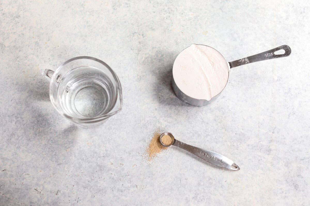 top shot of yeast, flour and water measured out to show how to bake with yeast. 