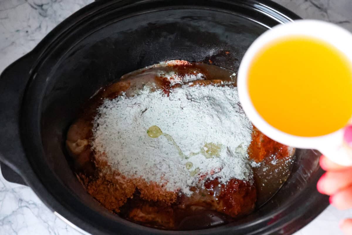 Second process photo of the chicken broth pouring into the slow cooker.