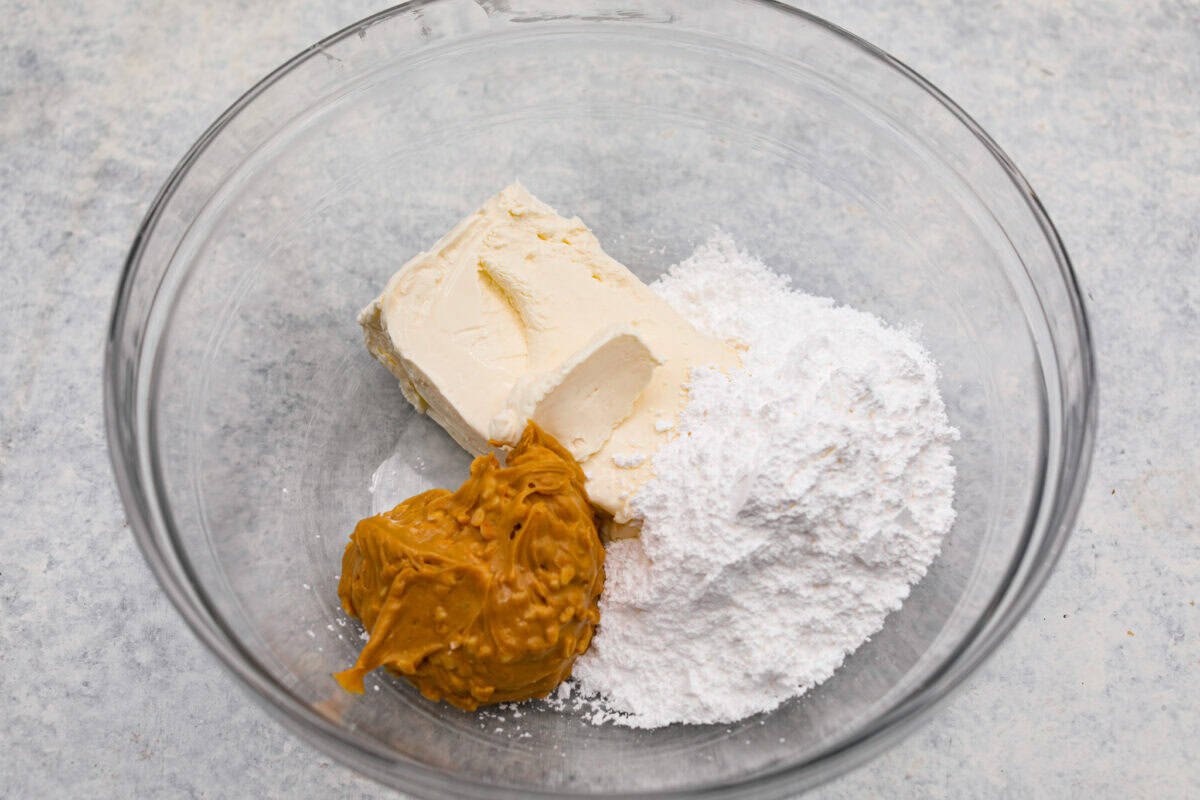 Cream cheese, peanut butter and powdered sugar in a glass bowl. 