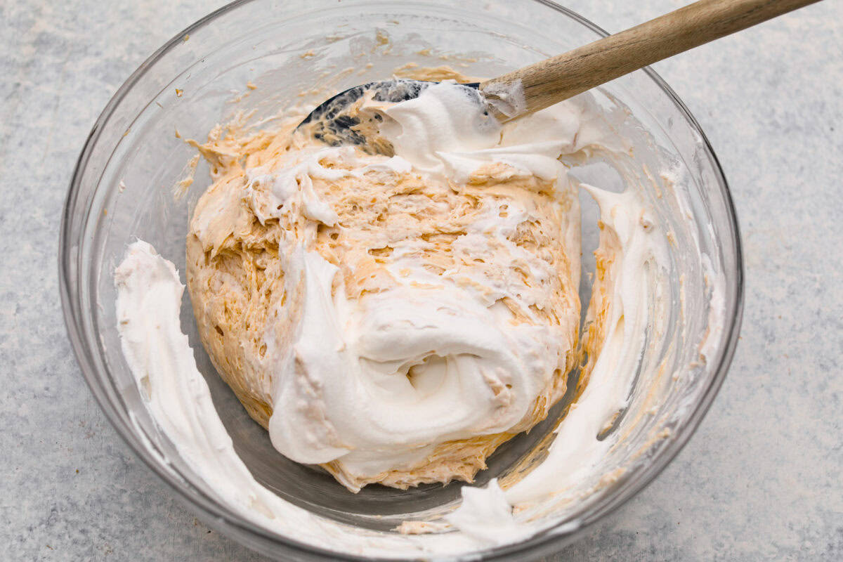 Whipped Topping being added into the bowl of ingredients. 