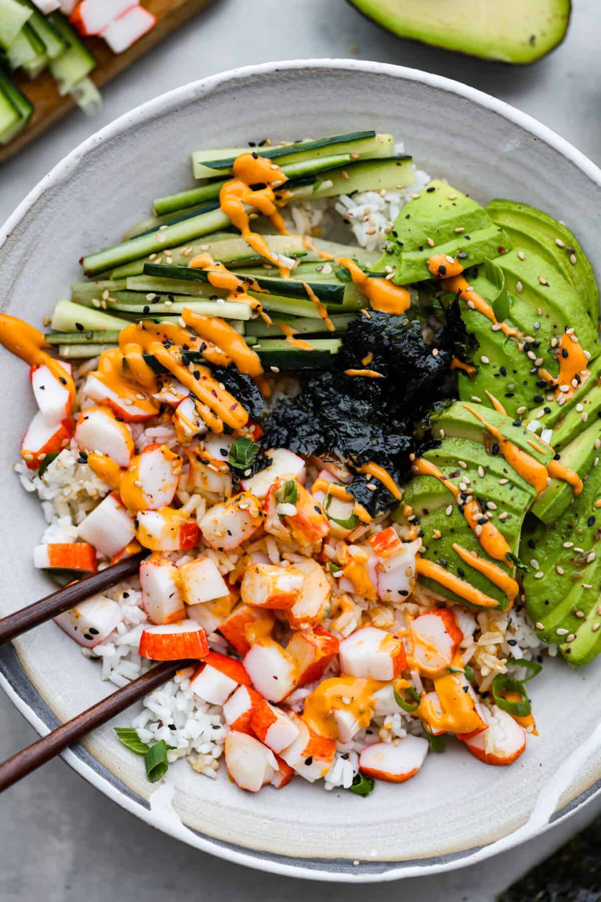 Overhead shot of sushi bowl with chopsticks. 