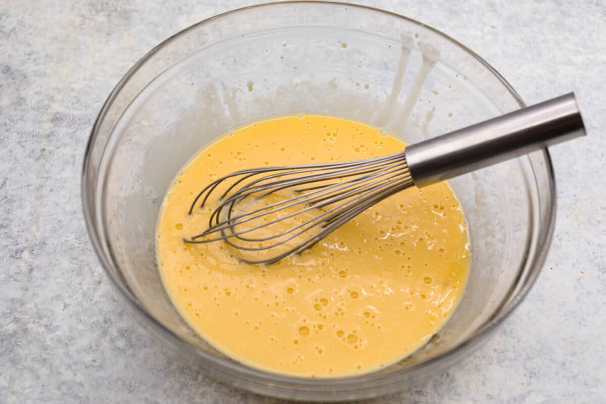 Wet ingredients whisked together in a glass bowl. 