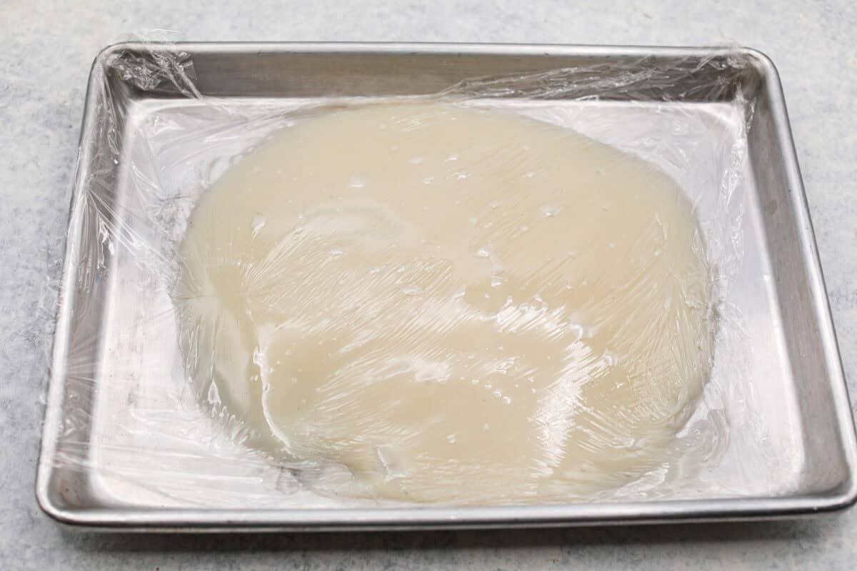 Top view of flour mixture on a baking sheet covered in plastic wrap. 