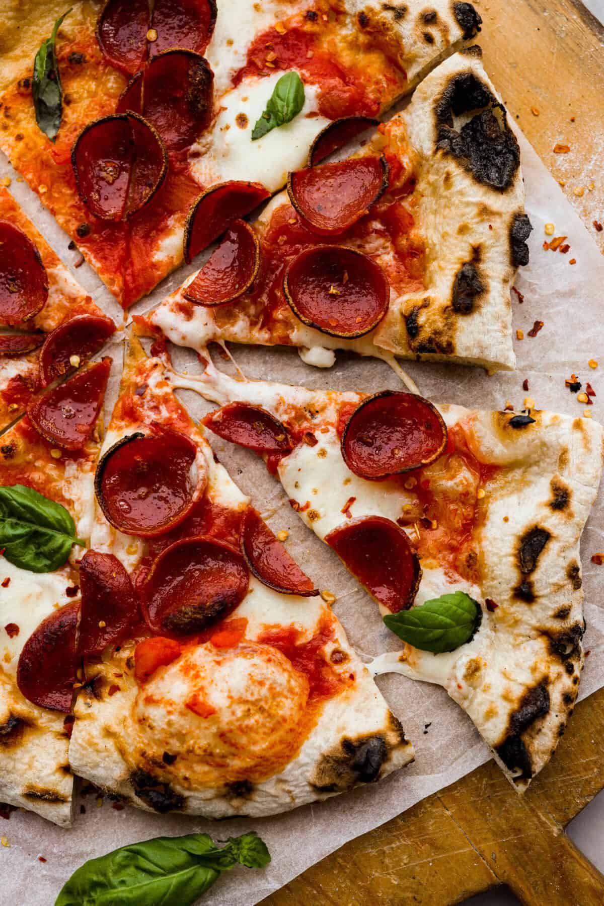 Top view of wood-fired pizza cut into slices.