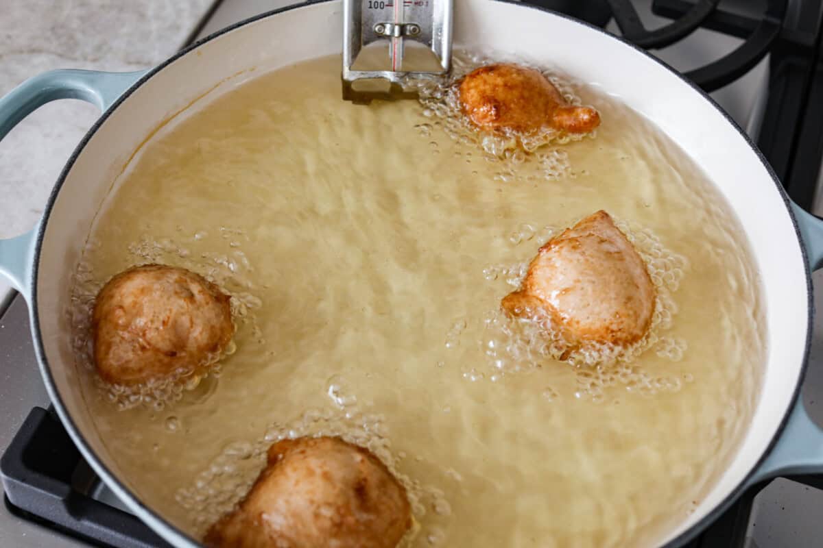 overhead shot of zeppole being fried in oil. 