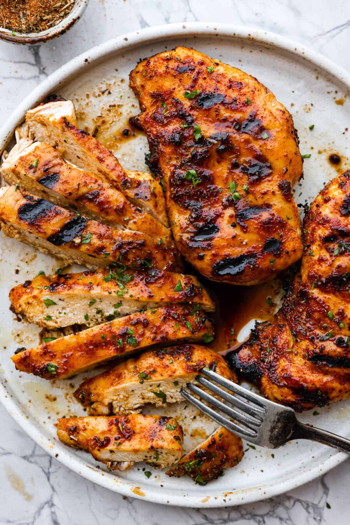 Top view of grilled chicken on a platter.