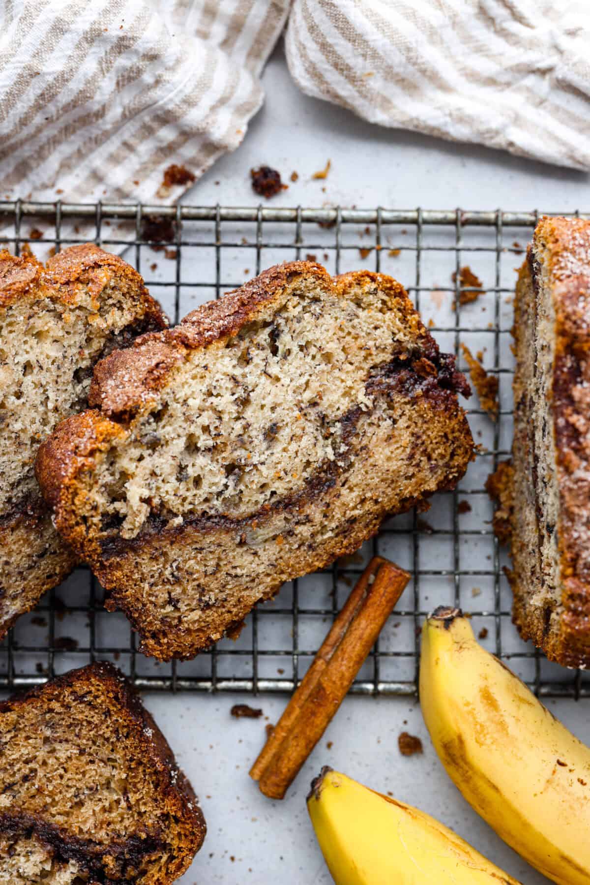 Overhead shot of a slice of cinnamon swirl banana bread on cooling rack. 