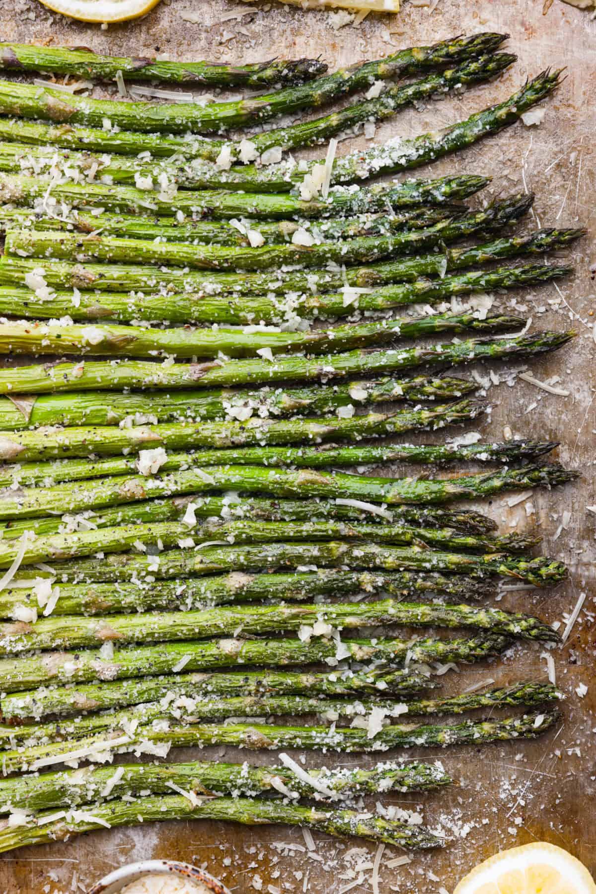 Top close view of roasted lemon parmesan garlic asparagus on a sheet pan.