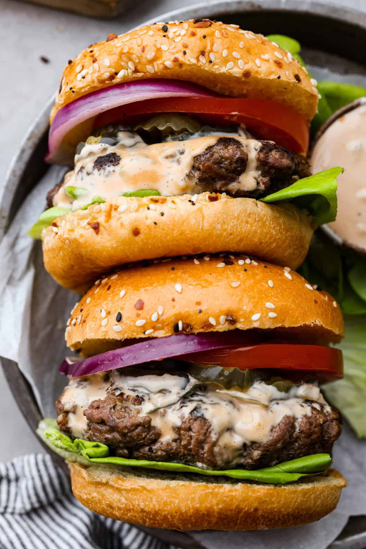 2 burgers laid on they side on a plate. 