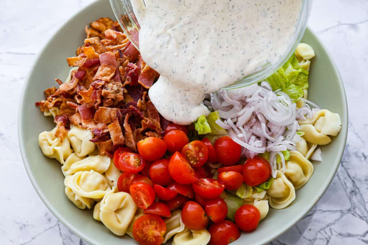 Overhead shot of dressing being poured over salad. 