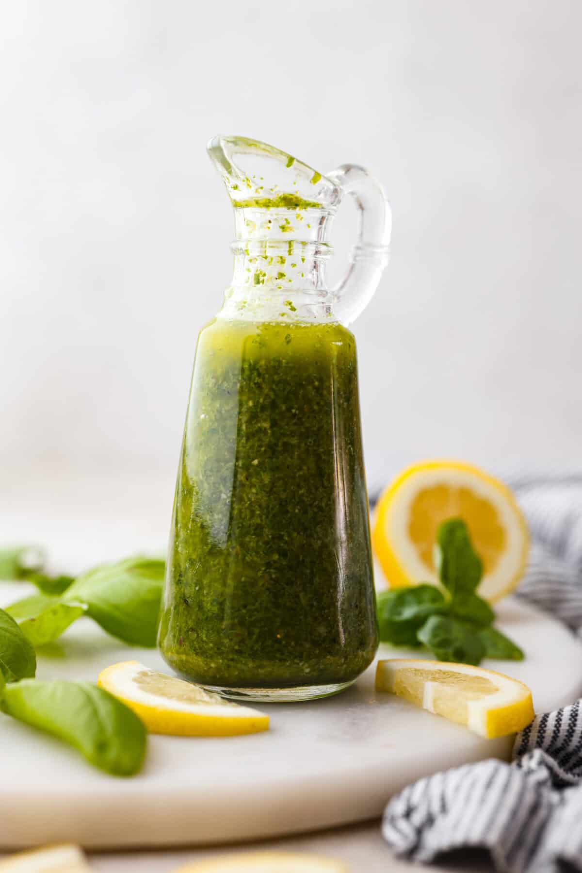 Side view of cute glass container with basil vinaigrette in side.  