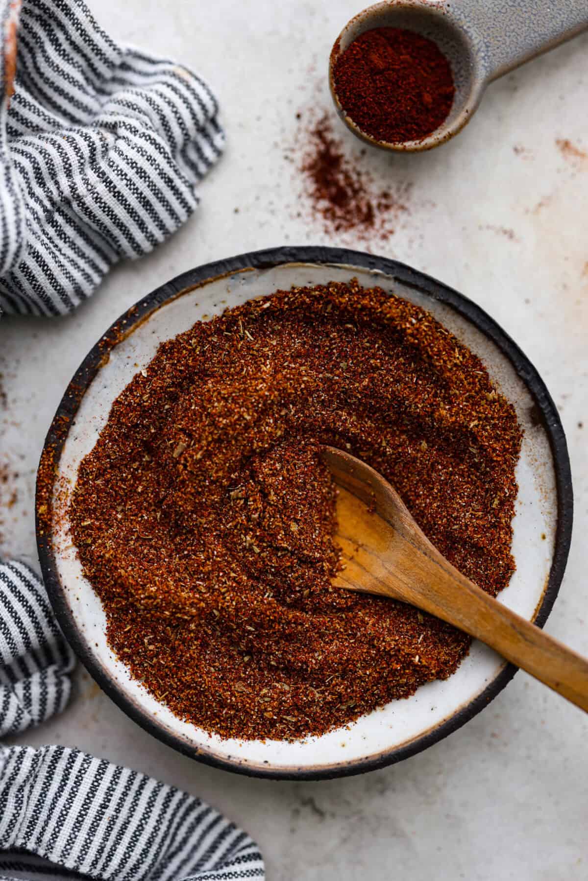 Overhead shot of mixed chipotle seasoning in a bowl with wooden spoon sticking out of it. 