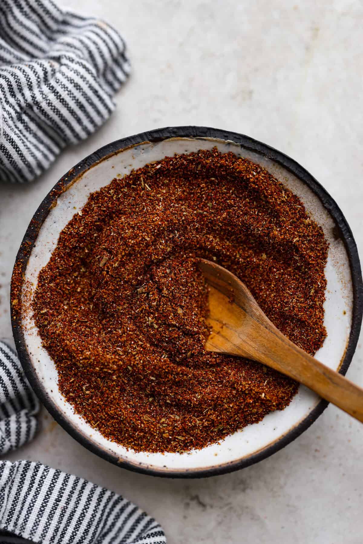 Overhead shot of mixed chipotle seasoning with wooden spoon in it. 