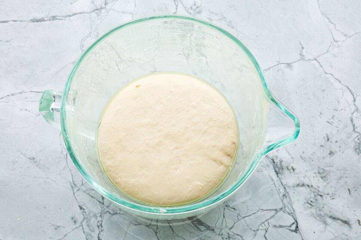 Overhead shot of dough in an oiled bowl. 