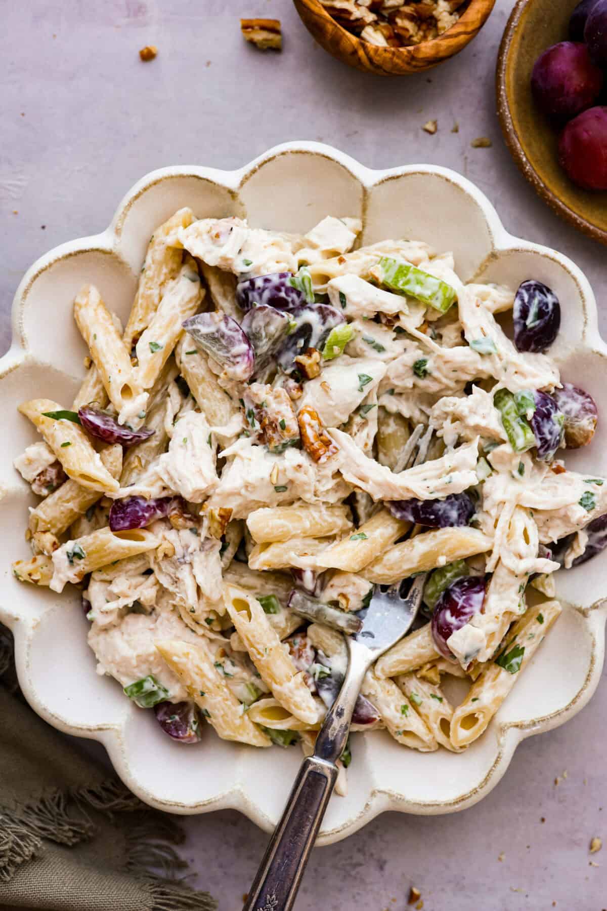 Overhead shot of a serving of pasta salad in a bowl with a fork. 