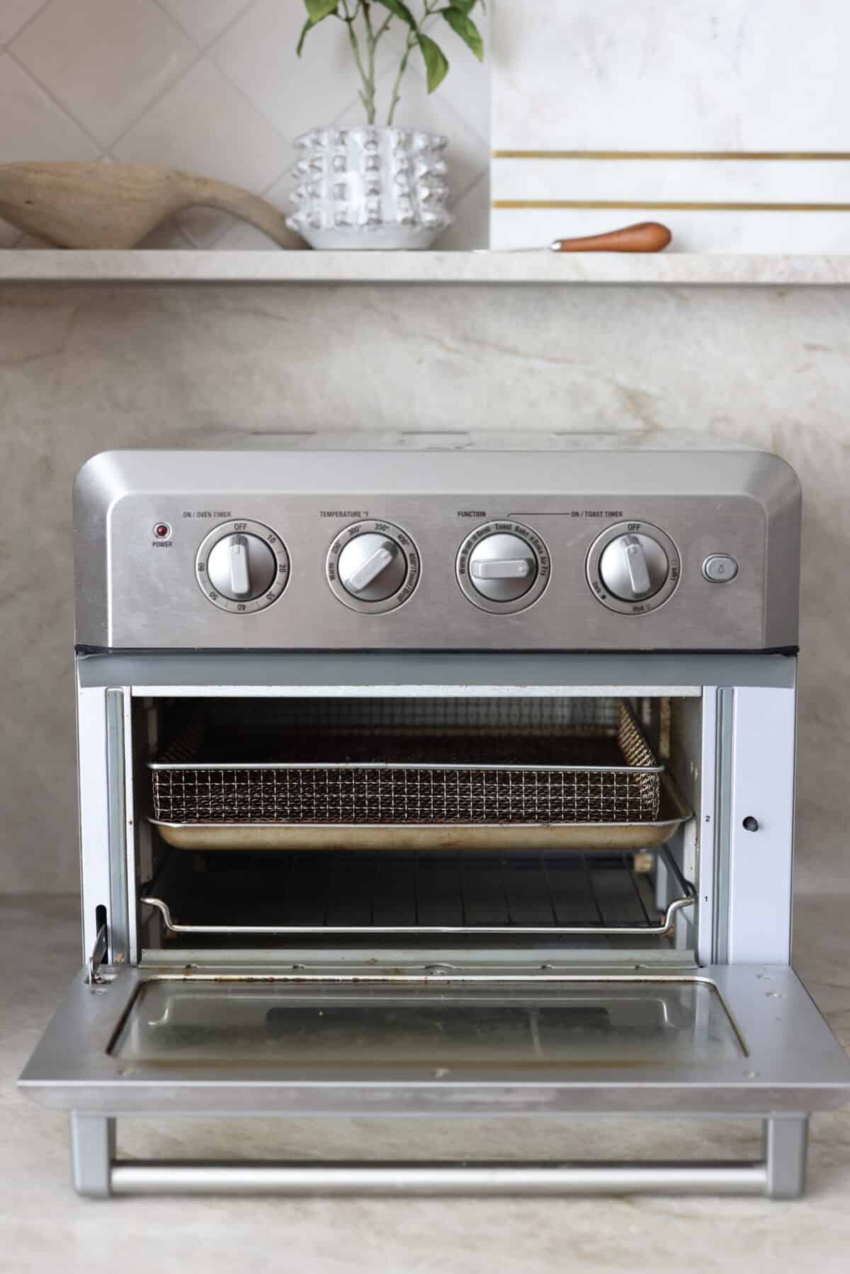 Close view of a toaster oven air fryer with the door open.