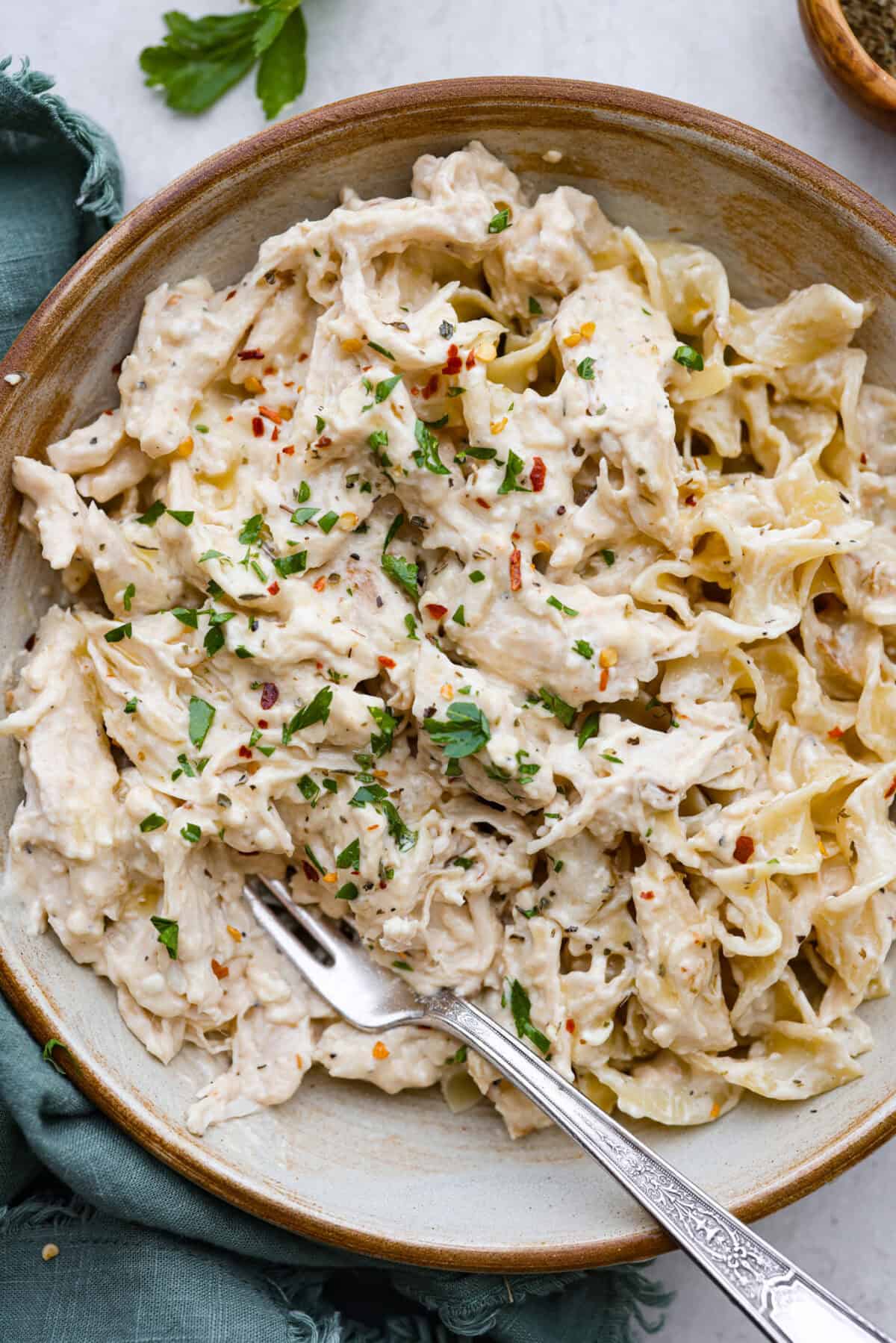 Overhead shot of a bowl of Italian cream cheese chicken over egg noodles. 