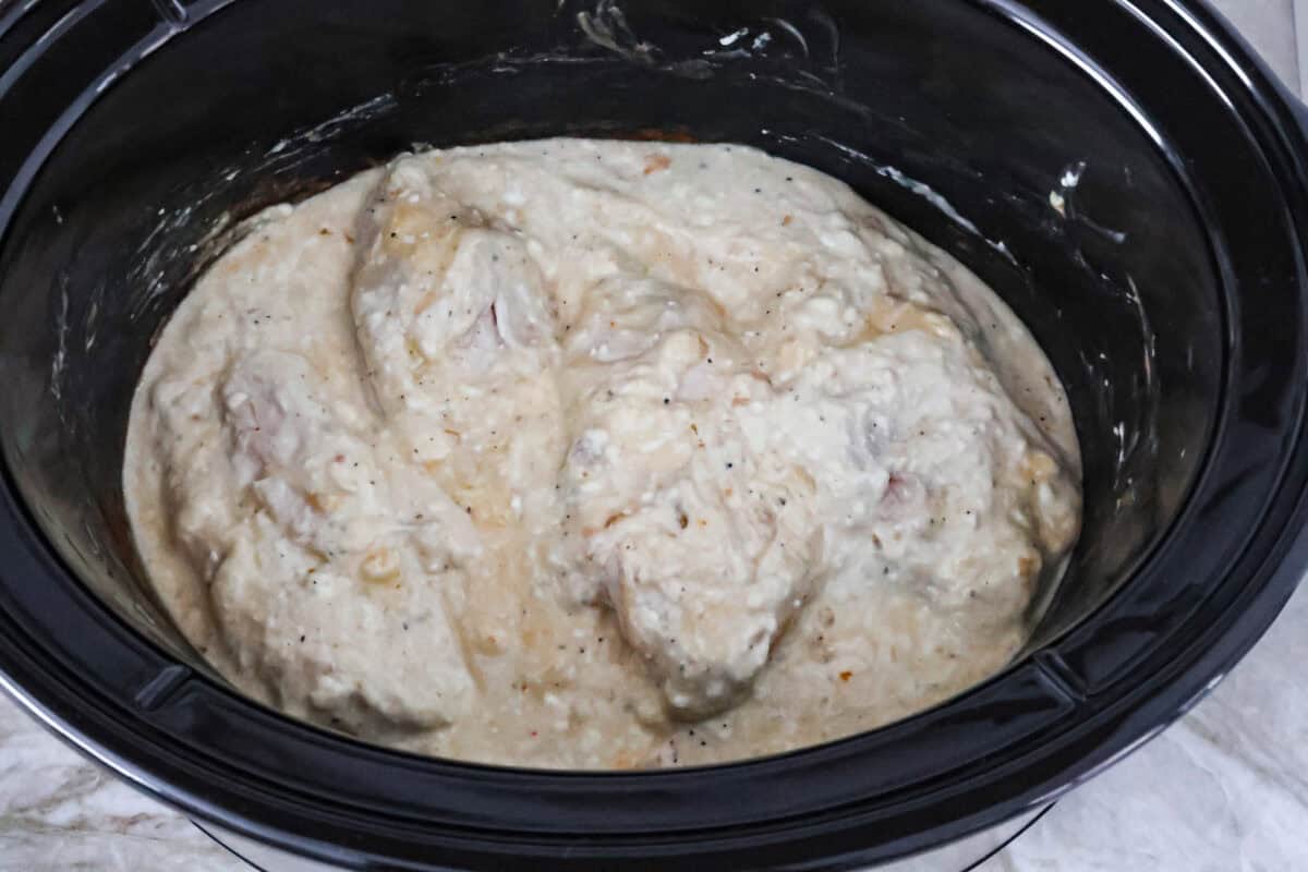 Overhead shot of flipped chicken and mixed cream cheese sauce. 