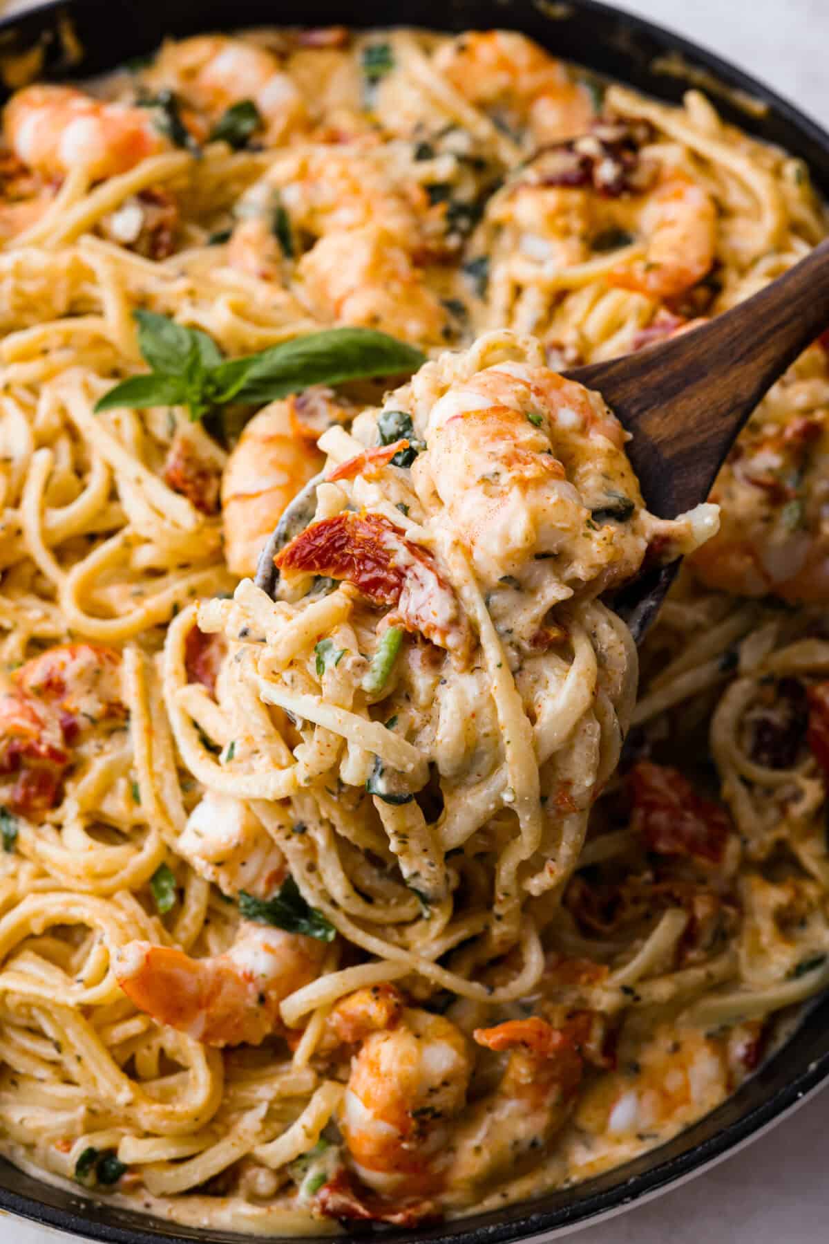 Angle shot of close up pasta with scoop being taken out of it.