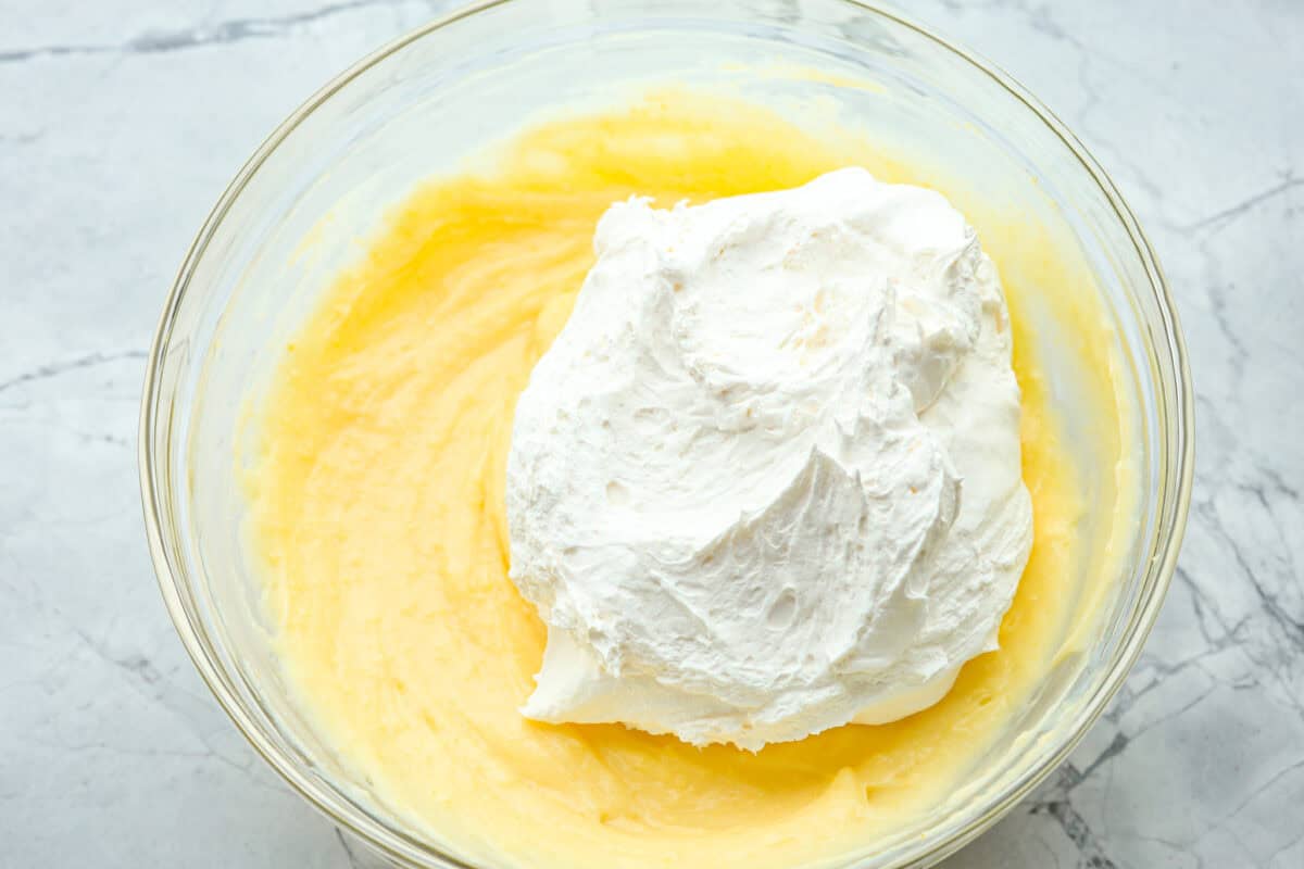 Cool whip being folded into the raspberry fluff salad mixture. 