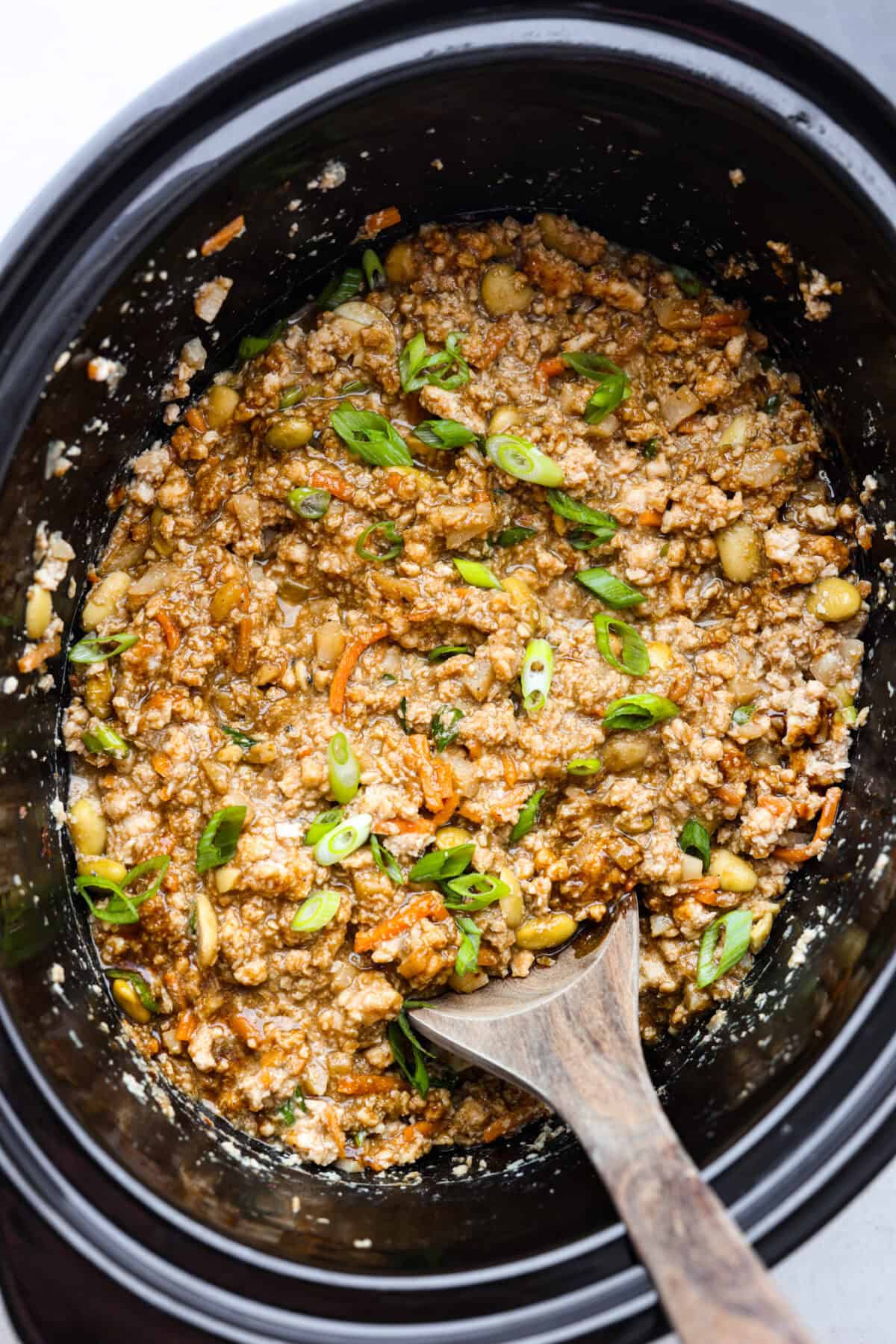 Overhead shot of completed asian lettuce wrap filling stirred up in crock pot. 