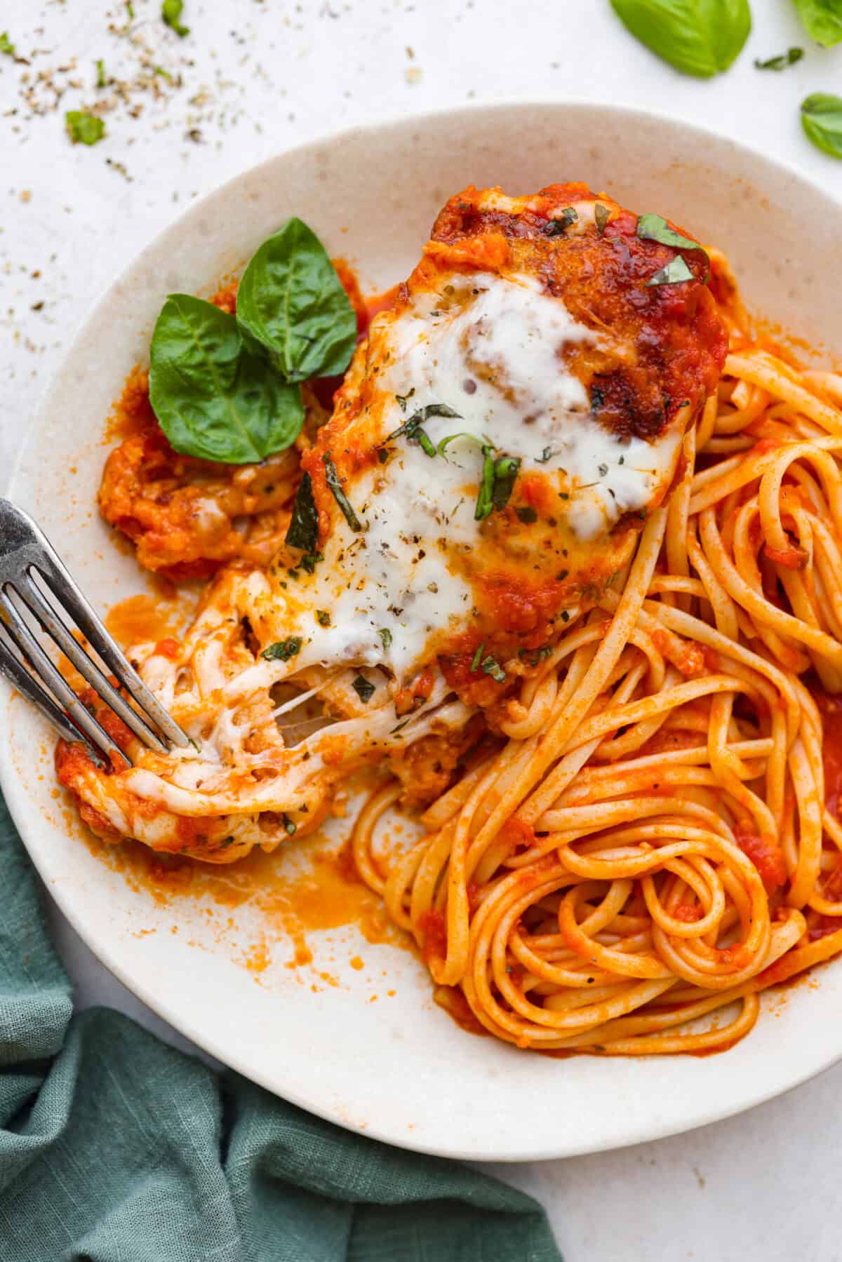 Overhead shot of plated slow cooker chicken parmesan over noodles. 