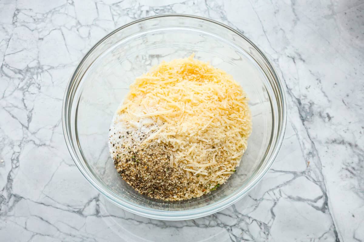 Overhead shot of breading ingredients a glass bowl. 