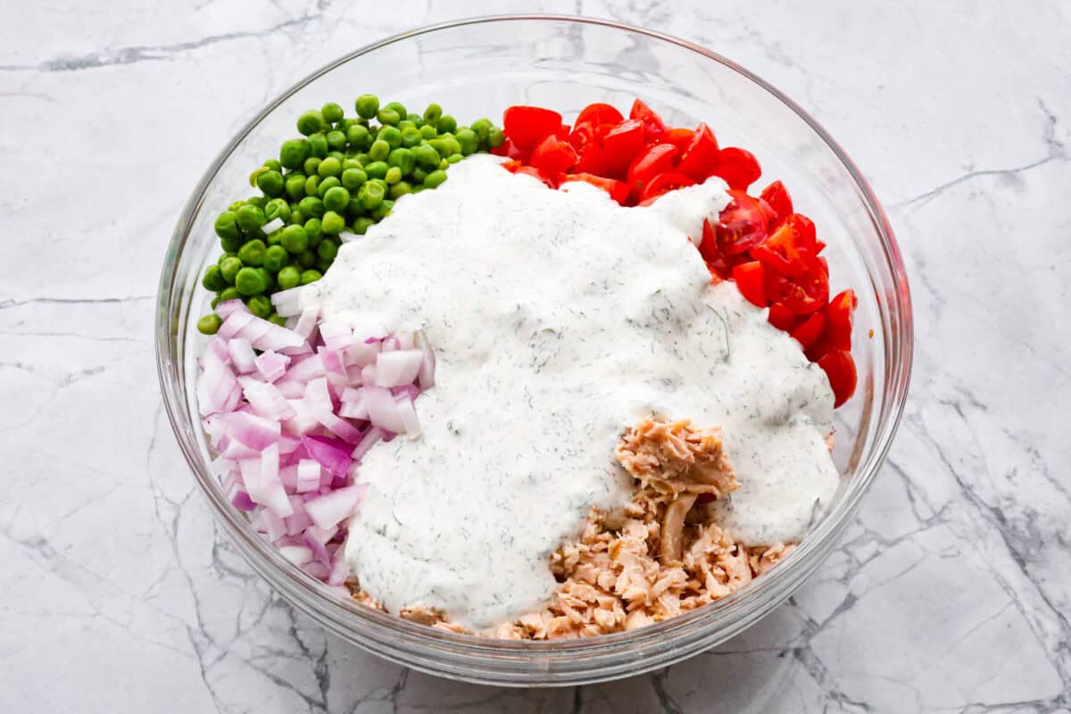 Third photo of the dressing poured on top of the salad ingredients before tossing.