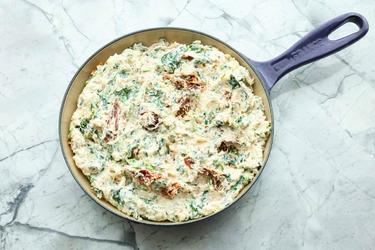 Fourth photo of the dip spread into a skillet before baking.