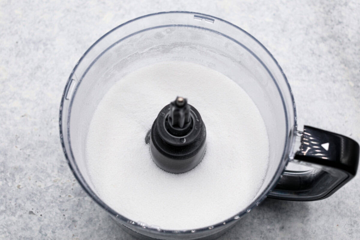 Overhead shot of granulated sugar in food processor. 