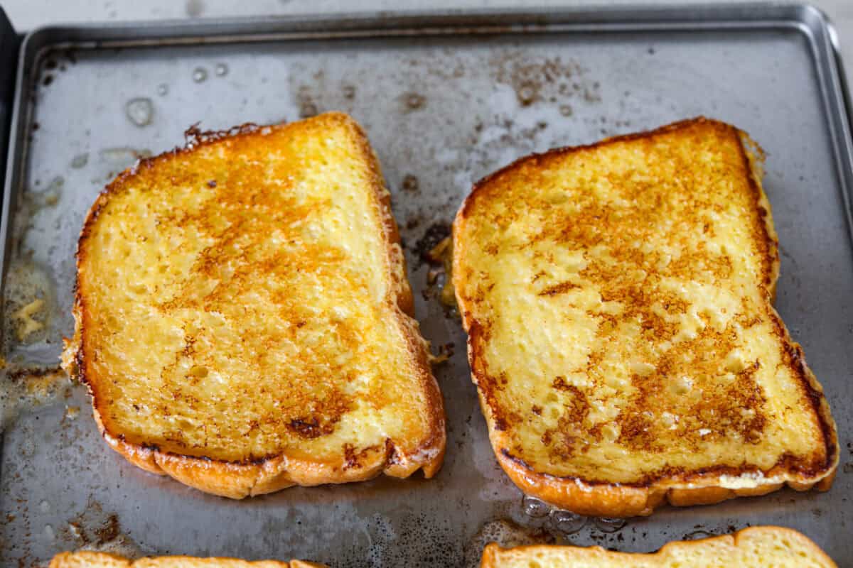 Fifth photo of the French toast cooking on the griddle.