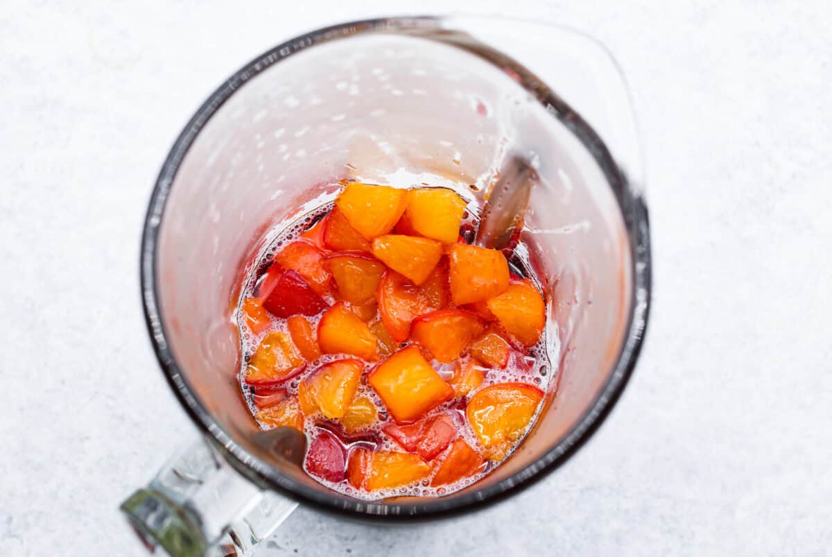 Overhead shot of peach mixture in a blender. 