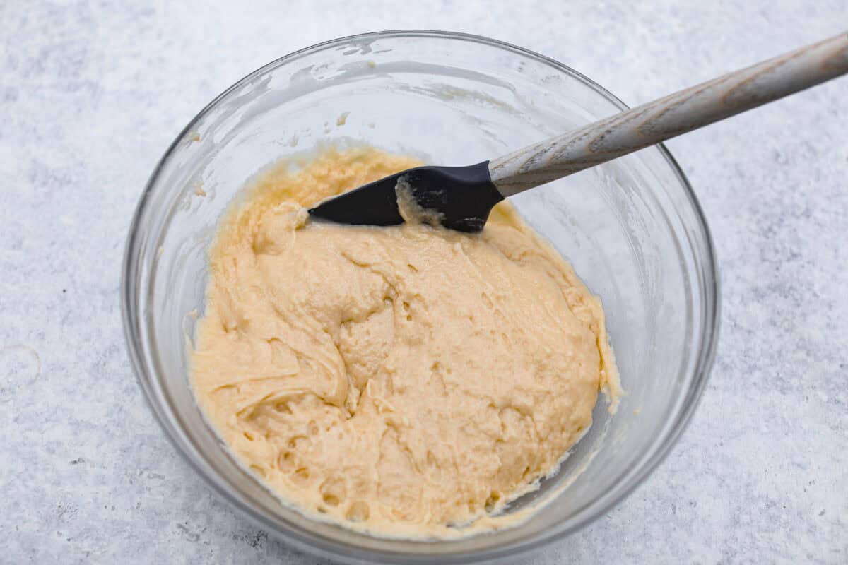 Overhead shot of wet and dry ingredients mixed in a glass bowl. 