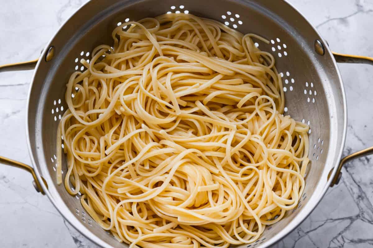 Overhead shot of cooked and drained noodles in a colander. 