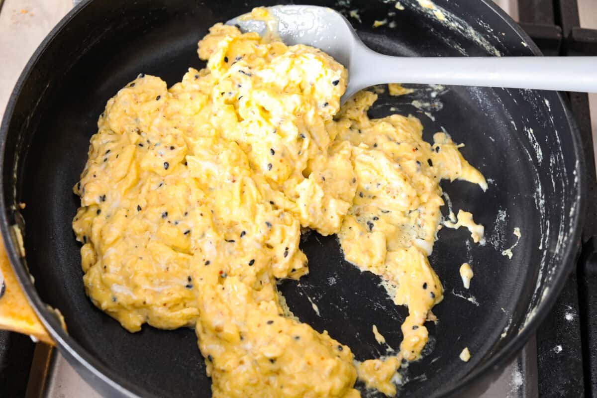 Overhead shot of egg mixture being scrambled in a pan. 