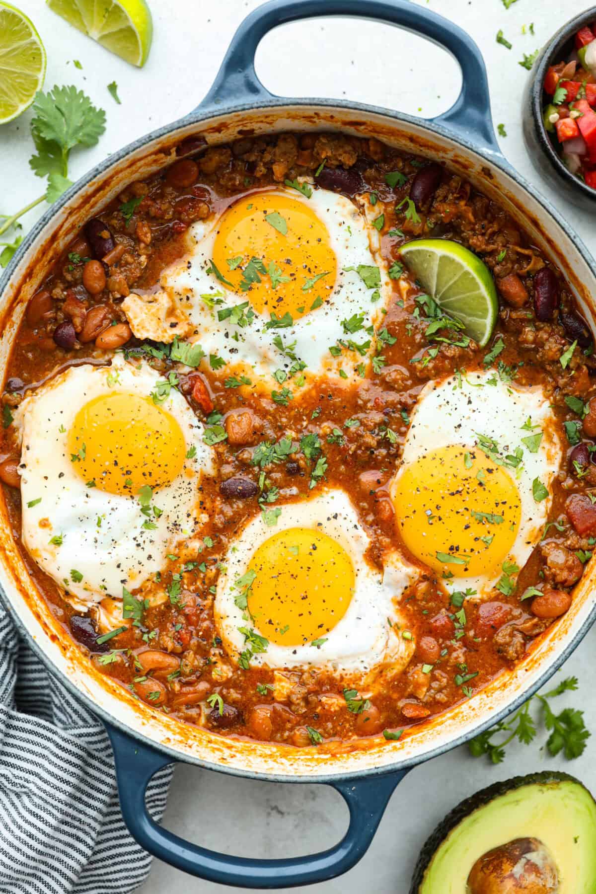 Overhead shot of breakfast chili with 4 eggs cooked on top. 