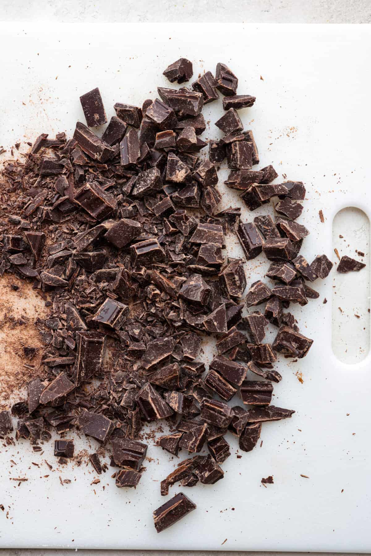 Top view of chopped chocolate on a cutting board.