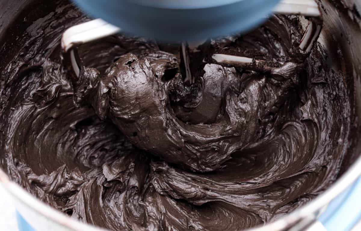 Overhead shot of the black frosting being whipped in a stand mixer. 