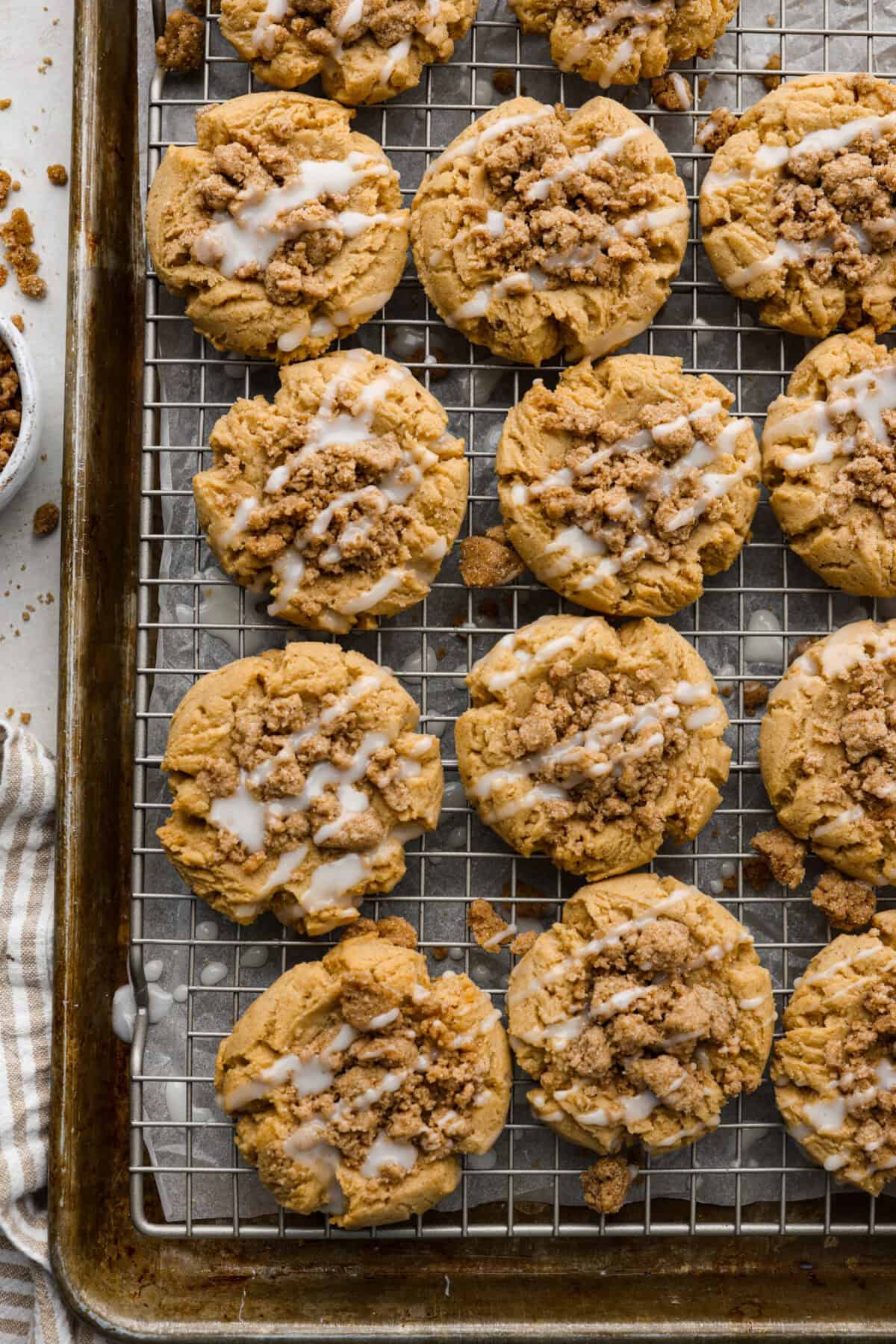 Overhead shot of coffee cake cookies on a cooling rack over a baking sheet. 