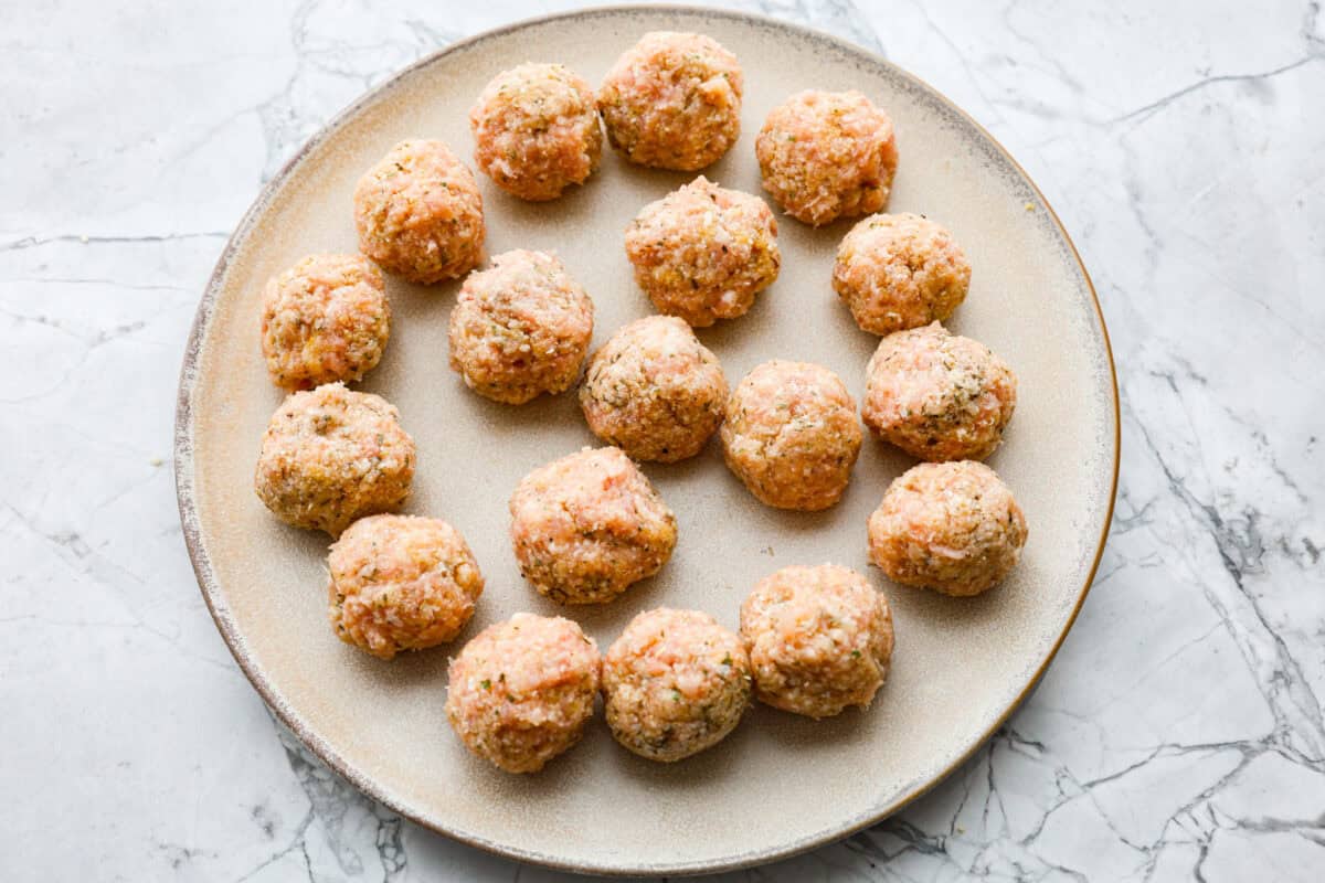 Overhead shot of meatballs formed on a plate. 