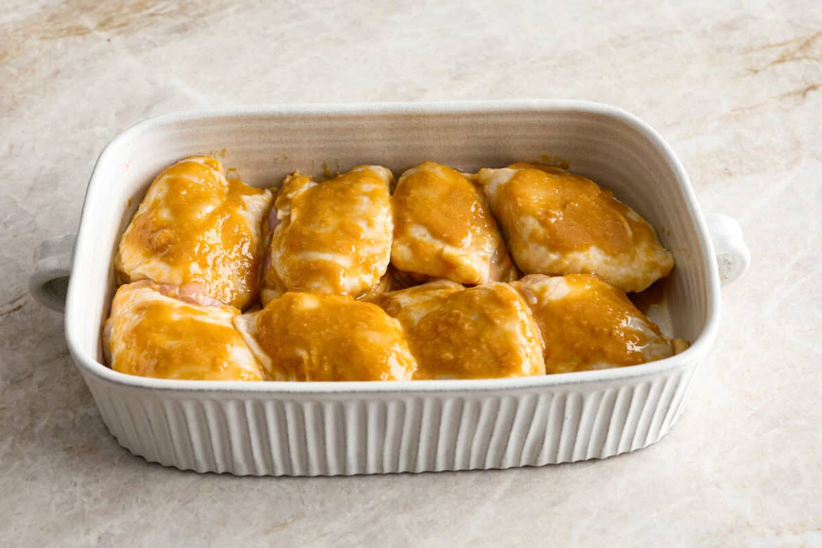 Angle shot of marinated chicken in a baking dish. 