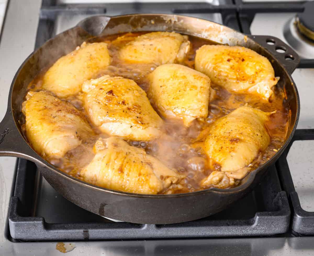 Angle shot of coca-cola chicken cooking in the skillet. 