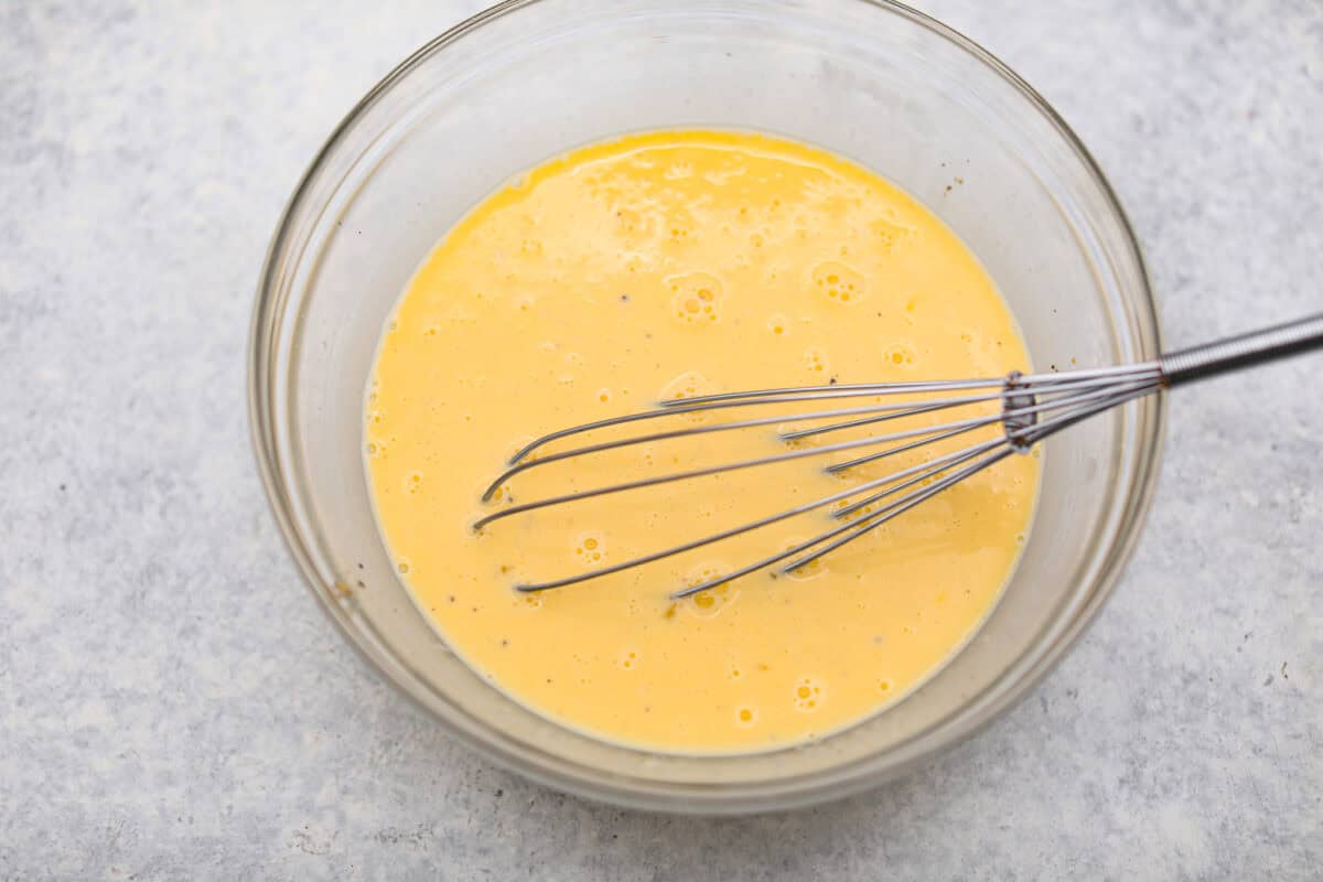 Overhead shot of egg mixture in a glass bowl.